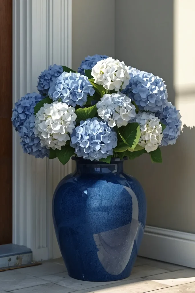 22 Front Porch Flower Ideas That Make Your Home's Entrance Bloom Beautifully 14 large glazed blue ceramic pot filled with full blue and white hydrangea blooms,
