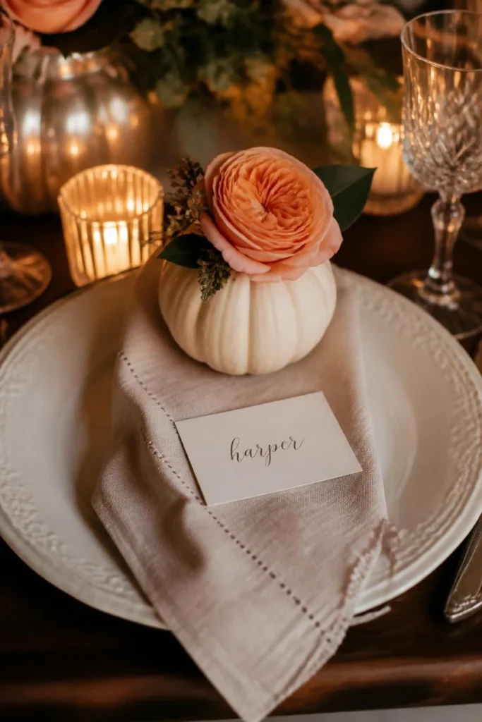 15 Pumpkin Floral Arrangement Ideas for Fall Tables That Feel Effortlessly Elegant 13 place setting, featuring a small mini pumpkin holding a single garden rose positioned above a dinner plate,