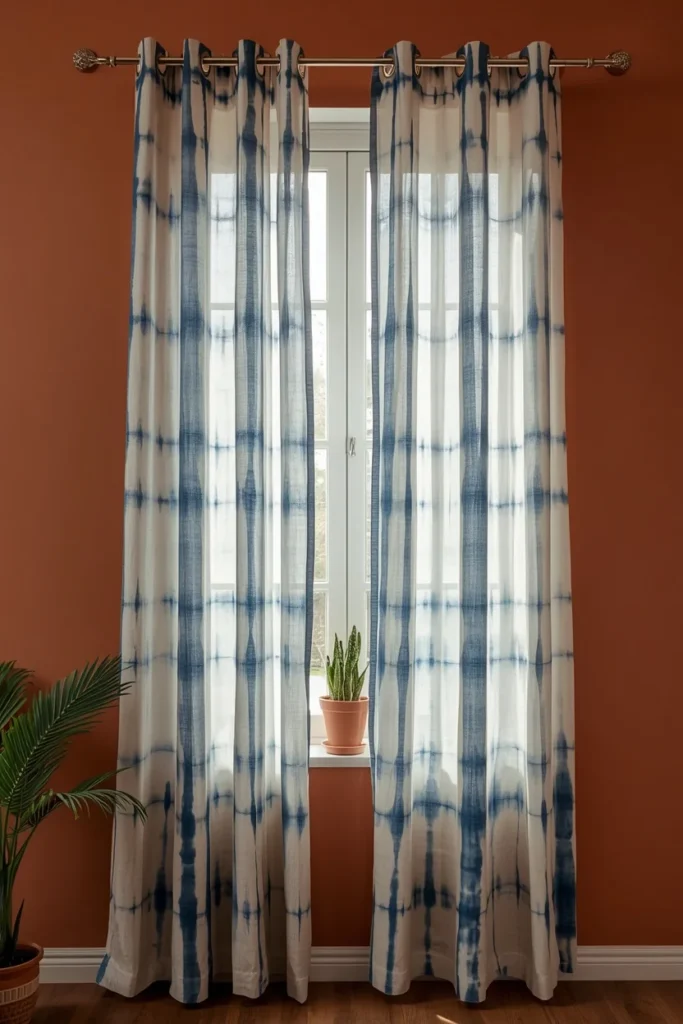  window styling shot, featuring lightweight indigo tie-dye curtains hanging on a brass curtain rod