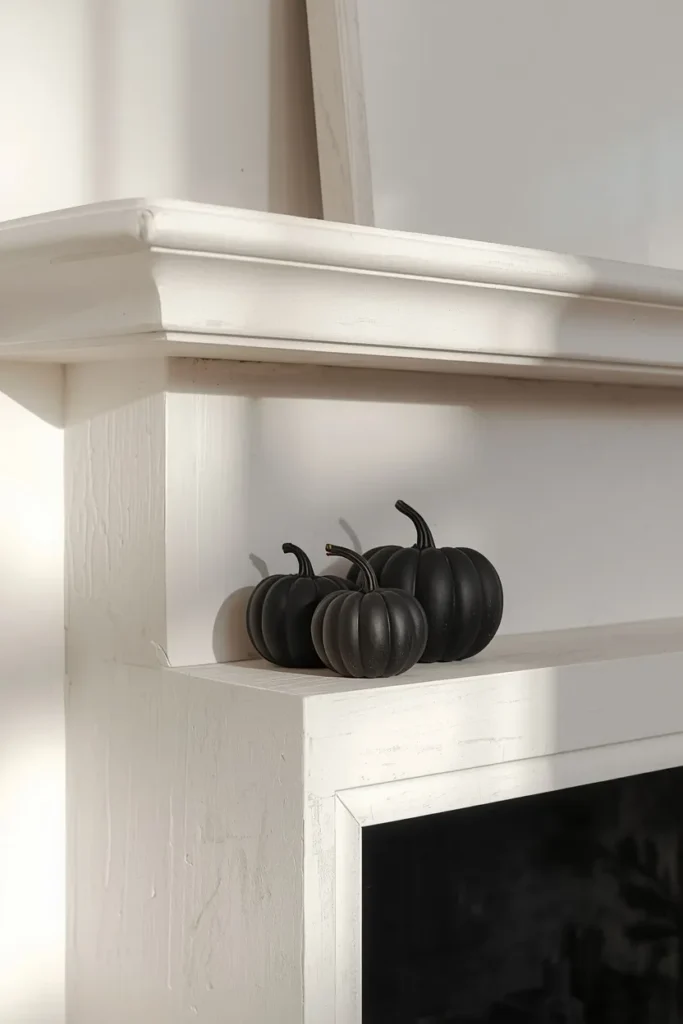 16 Modern Halloween Mantle Decor Ideas That Feel Fresh 2 modern fireplace mantel close-up, featuring three matte black pumpkins