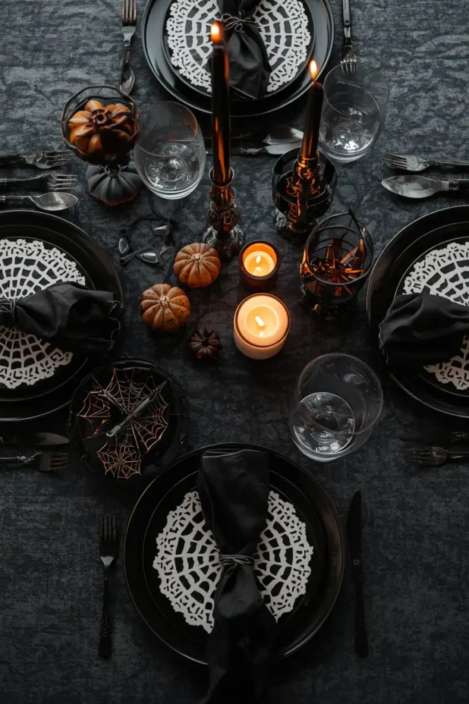 25 Whimsical Halloween Decor Ideas That Feel Spooky and Cute 13 table setting, featuring white spiderweb-cutout paper doilies