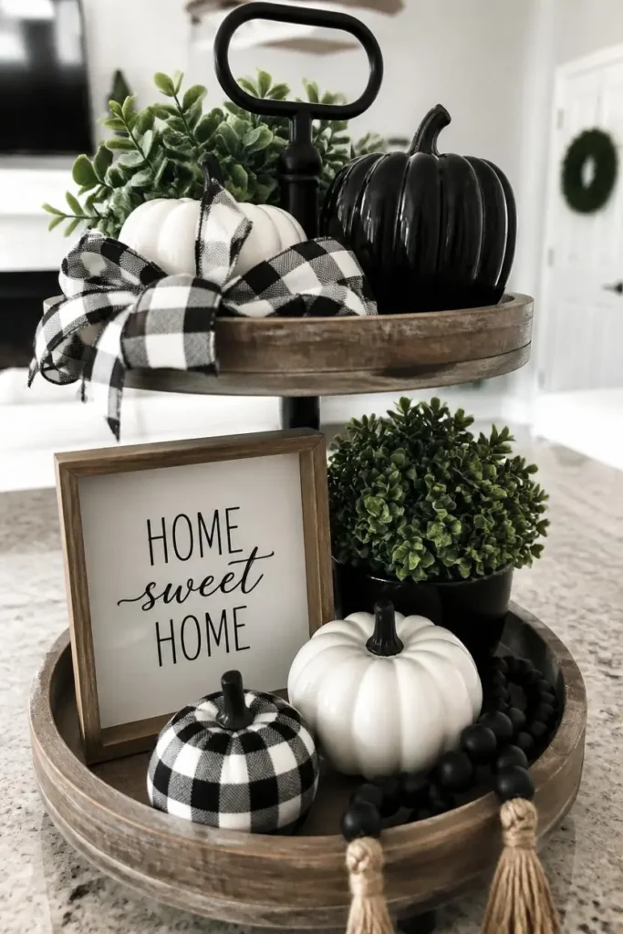  tiered tray close-up, featuring black and white ceramic pumpkins, 